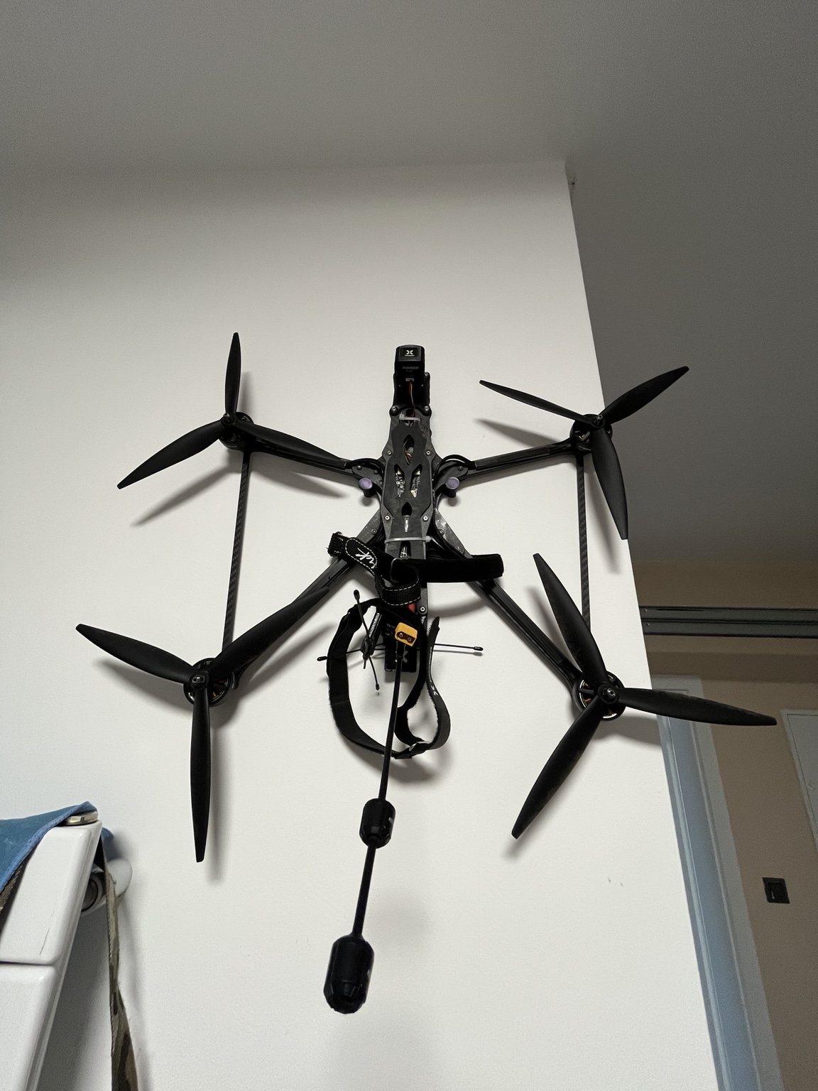 Reálný FPV dron uložený na nástěnném držáku Universal FPV Wall Mount